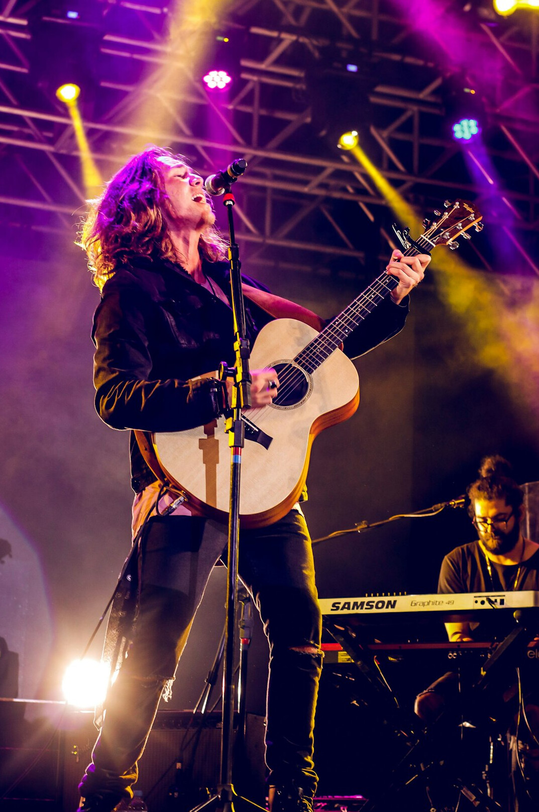 Musician performing on stage with guitar